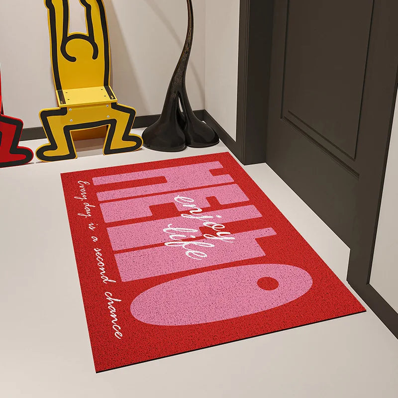 Tapis d'entrée de maison rouge et blanc avec un motif graphique et des formes géométriques.