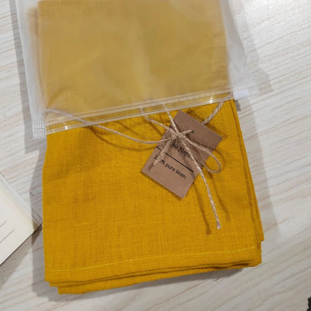 Serviettes en lin pur emballées et étiquetées, dans une couleur jaune moutarde vive.