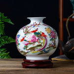 Un vase ornemental de style traditionnel chinois, décoré de magnifiques motifs de fleurs et d'oiseaux sur un fond blanc.