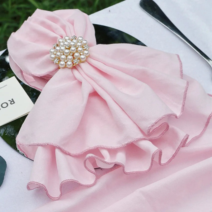 Une élégante fleur rose ornée de perles étincellantes, sur un fond de feuillage verdoyant.