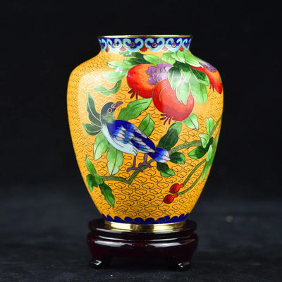 Vase en céramique décoré de motifs floraux et d'un oiseau bleu.
