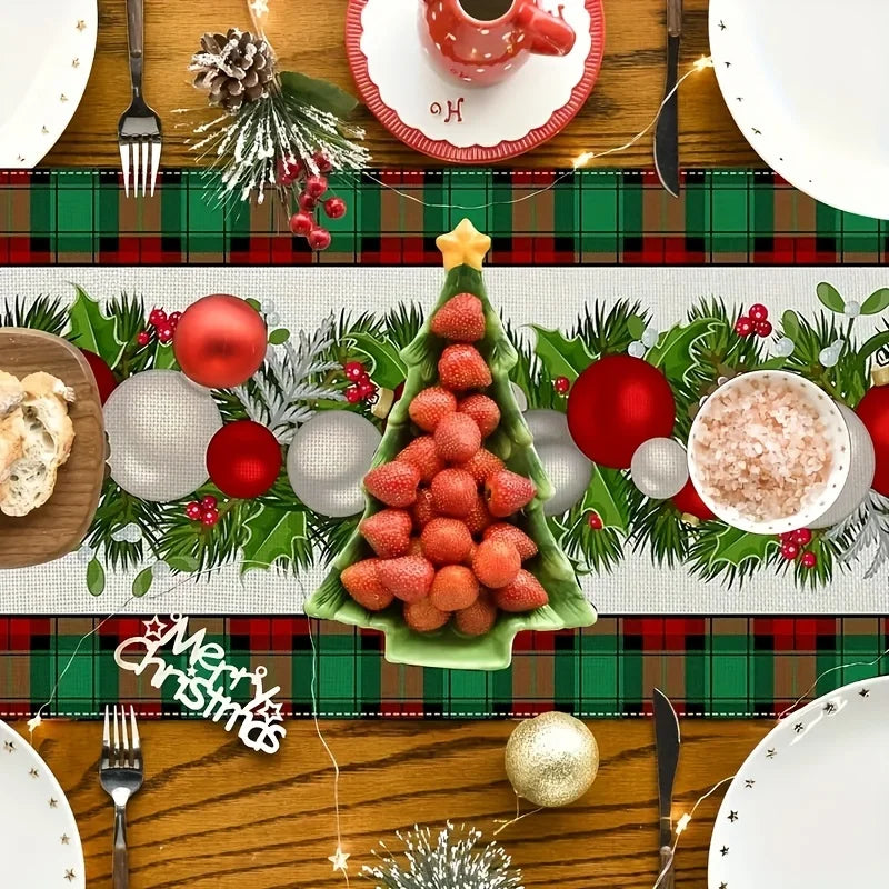 Une table de fête joliment décorée avec des ornements de Noël et des mets festifs, comprenant notamment un arbre de Noël fait de fraises et des boules rouges et blanches.