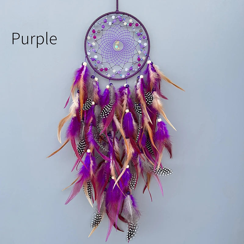 Un capteur de rêves décoratif de couleur violette, composé de perles, de plumes colorées et de motifs ornementaux.