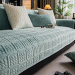 Un canapé confortable et douillet, avec des coussins moelleux de couleur vert pastel et une belle décoration végétale, créant une atmosphère chaleureuse et accueillante dans cette pièce.