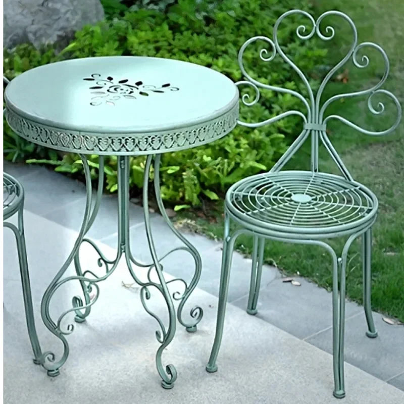 table extérieure ronde métal ajouré vintage chaises motifs floraux patio jardin