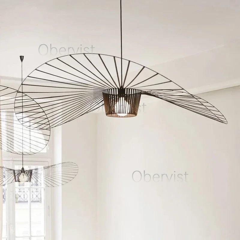 Lustre suspension rotin noir allumé dans une cuisine moderne