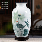 Vase décoratif en porcelaine blanche orné de motifs floraux de lotus et de détails en noir et gris.