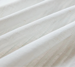 Vue rapprochée des plis du tissu blanc fin et texturé du voilage.