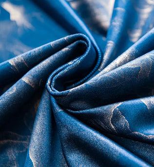 Zoom sur le tissu bleu foncé du rideau aux motifs délicats et finition satinée