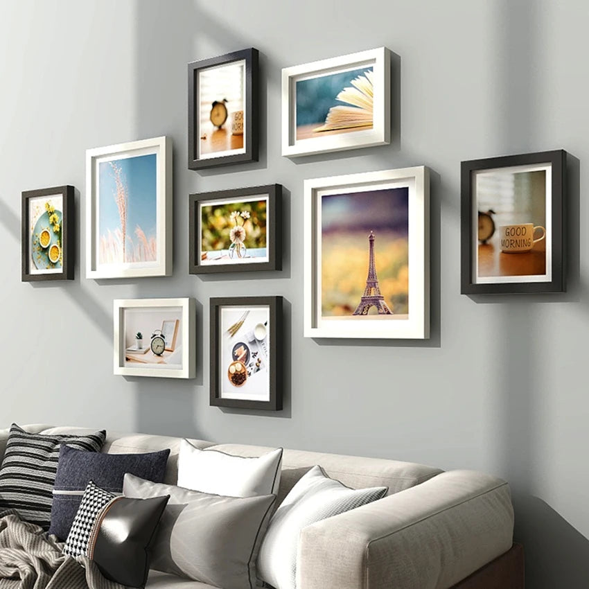 Ensemble de 9 cadres photo en bois naturel sur un mur blanc