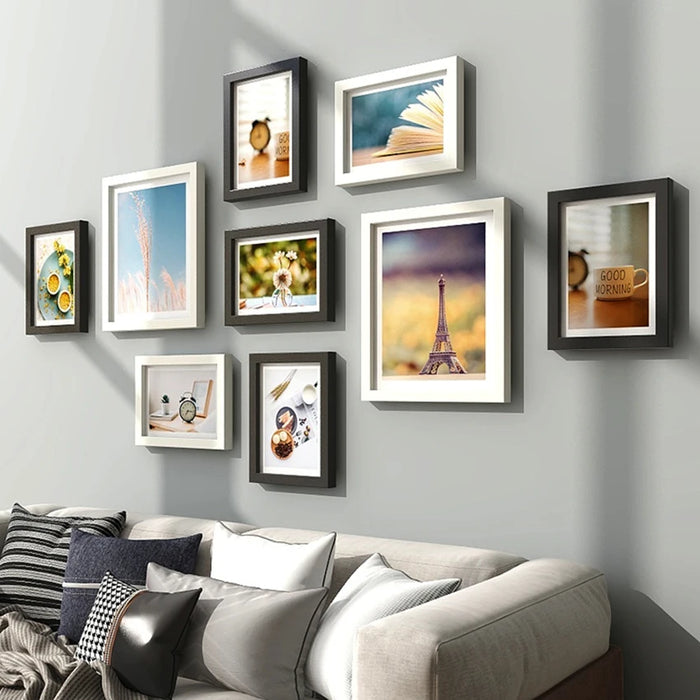 Ensemble de 9 cadres photo en bois naturel sur un mur blanc