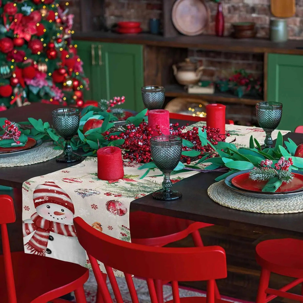 Table de Noël festive avec décorations rouges et vertes, bougies allumées, vaisselle et accessoires.