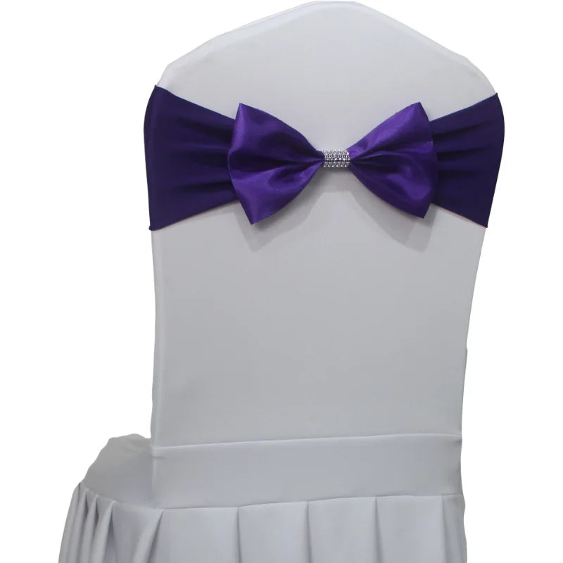 Une élégante chaise blanche ornée d'un nœud papillon violet foncé, prête à accueillir un invité pour un événement spécial.
