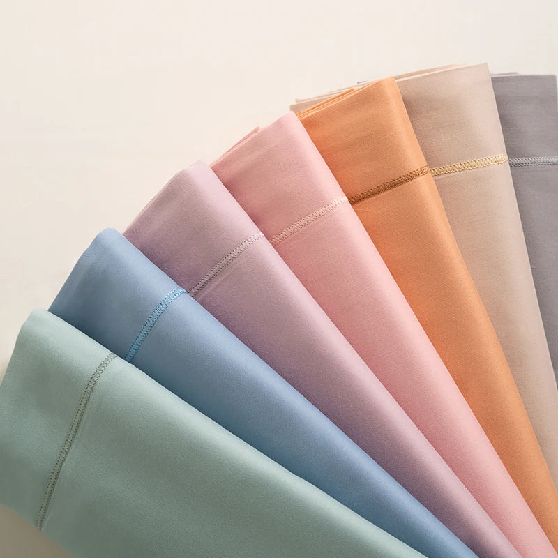 Une variété de tissus en couleurs pastelles douces, présentés sous forme de palette de teintes.