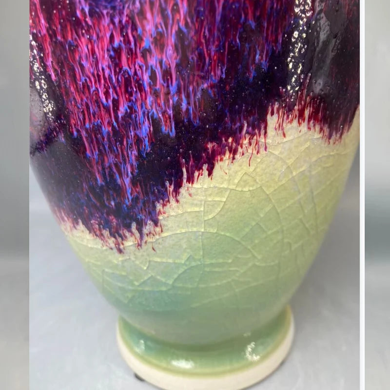 Une boisson colorée aux reflets violets et rouges dans un verre décoré de feuilles vertes.