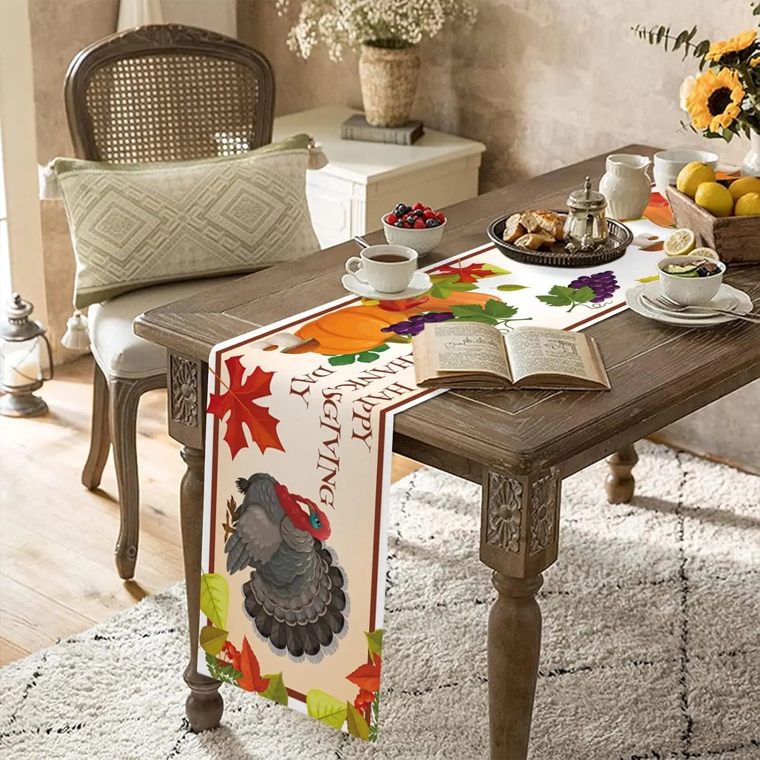 Une belle table de salon couverte d'un chemin de table décoré de feuilles d'automne et d'un beau poulet, accompagnée de fruits et d'un livre ouvert, créant une ambiance chaleureuse et confortable.