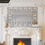 Un élégant foyer en marbre sculpté avec un cadre décoratif orné de motifs géométriques en miroir, agrémenté d'accessoires dorés et de touches de décor subtiles.