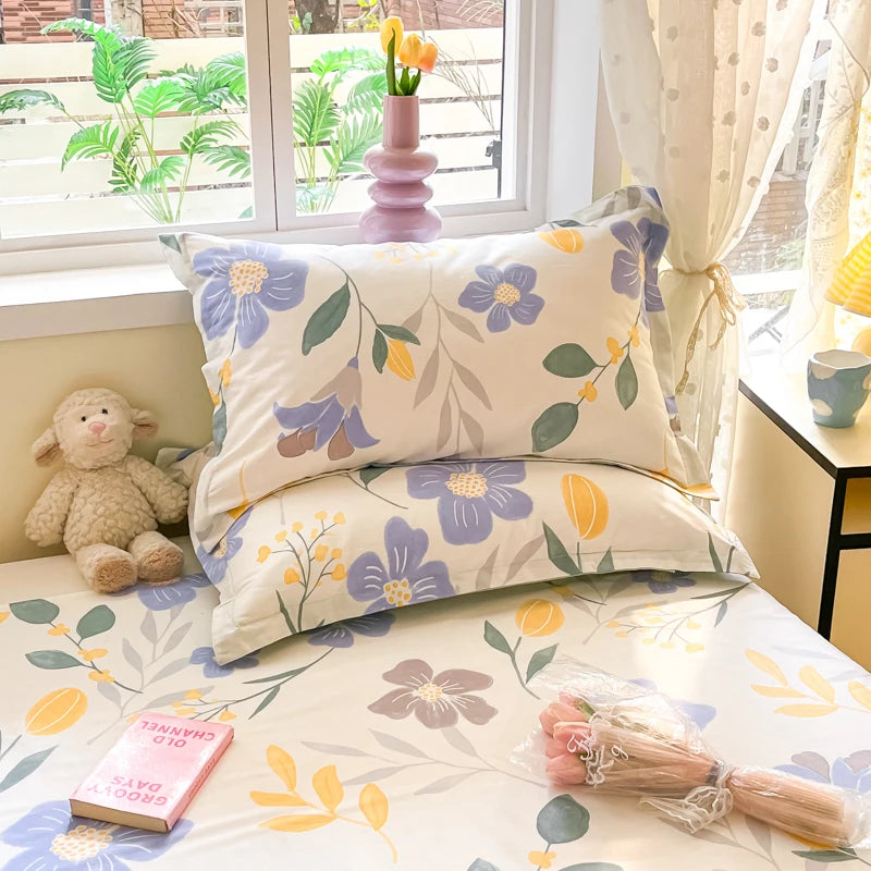 Une chambre lumineuse et accueillante, décorée de motifs floraux colorés sur les coussins et la literie, créant une ambiance chaleureuse et sereine.