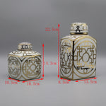 Deux vases décoratifs de formes et de motifs géométriques dorés et blancs.