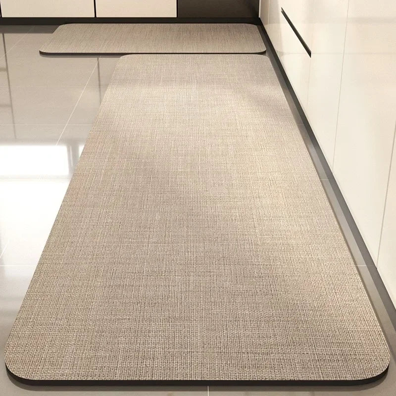Tapis en fibre grise texturée avec bordure noire sur un sol blanc et carrelé.