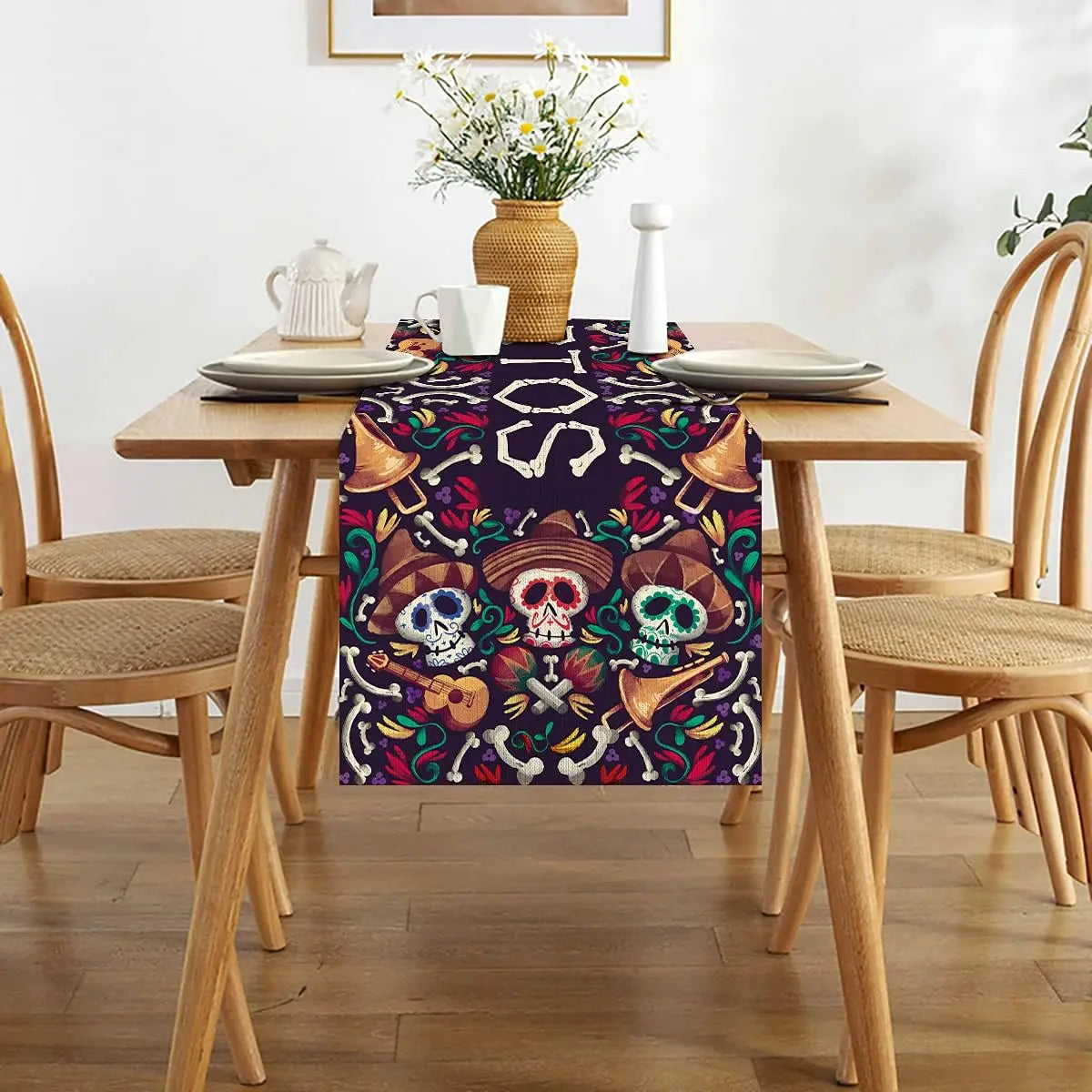 Nappe décorative multicolore avec imprimé de crânes de Calavera et autres motifs mexicains traditionnels sur une table de salle à manger en bois avec des chaises.