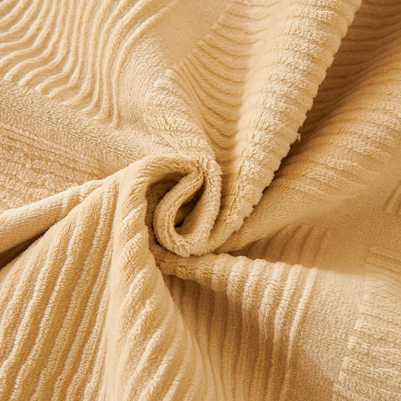 Un gros plan sur un tissu doux et moelleux aux plis délicatement ondulés, dans une teinte chaleureuse et rassurante.