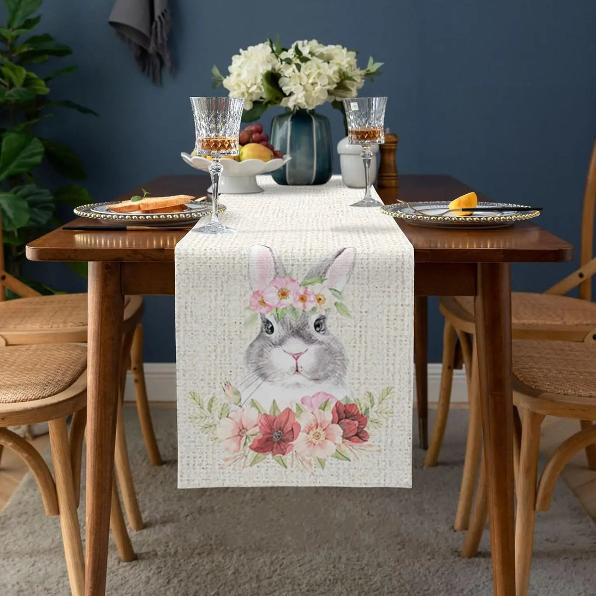 Une élégante composition de table avec des verres de cristal, des assiettes décorées et un bouquet de fleurs blanches créant une ambiance chaleureuse et raffinée.