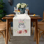 Une élégante composition de table avec des verres de cristal, des assiettes décorées et un bouquet de fleurs blanches créant une ambiance chaleureuse et raffinée.