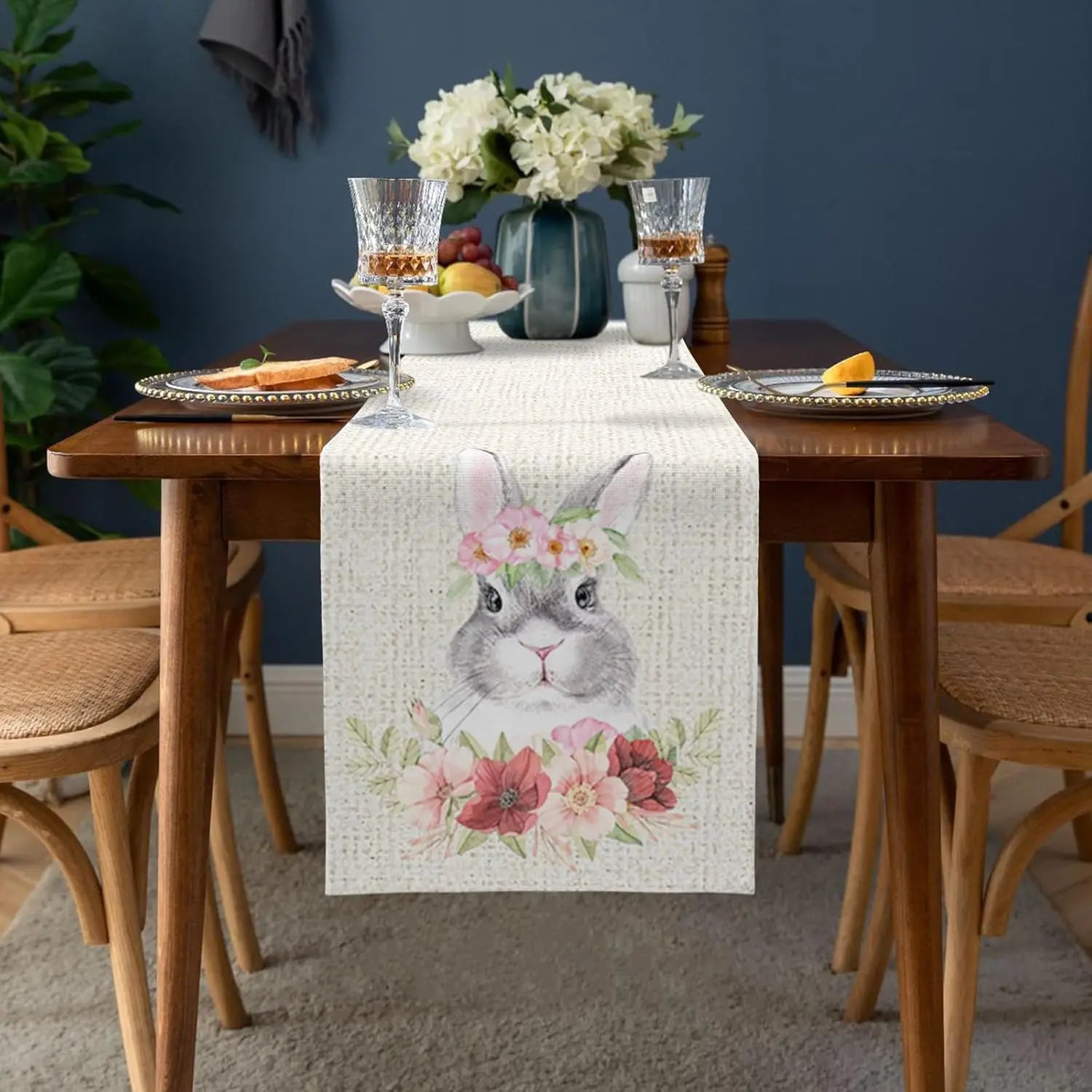 Une élégante composition de table avec des verres de cristal, des assiettes décorées et un bouquet de fleurs blanches créant une ambiance chaleureuse et raffinée.
