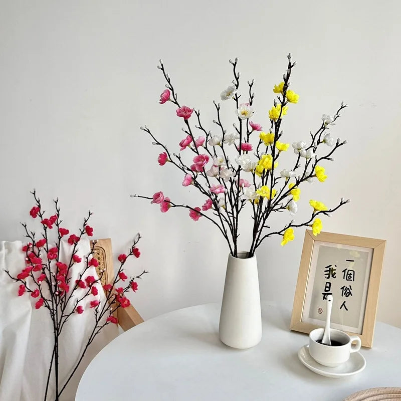 décoration intérieure moderne branchettes artificielles fleurs jaunes rouges blanches minimalistes maison événements