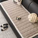 Tapis de sol moelleux et gris orné d'un motif rayé, avec des coussins décoratifs et des pantoufles confortables, créant un espace douillet et relaxant.