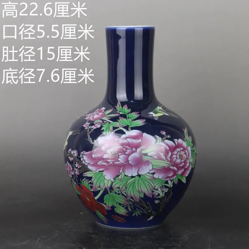 Vase décoratif en céramique de style oriental avec des motifs floraux peints à la main en couleurs vives sur un fond bleu foncé.