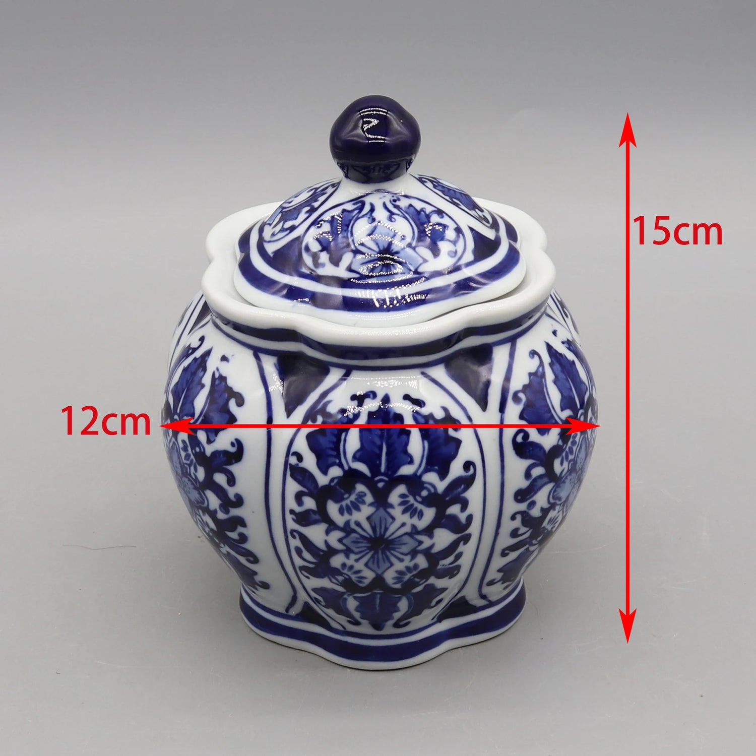 Un vase décoratif en porcelaine blanche et bleue avec un motif floral élégant, mesure 15 cm de hauteur et 12 cm de largeur.