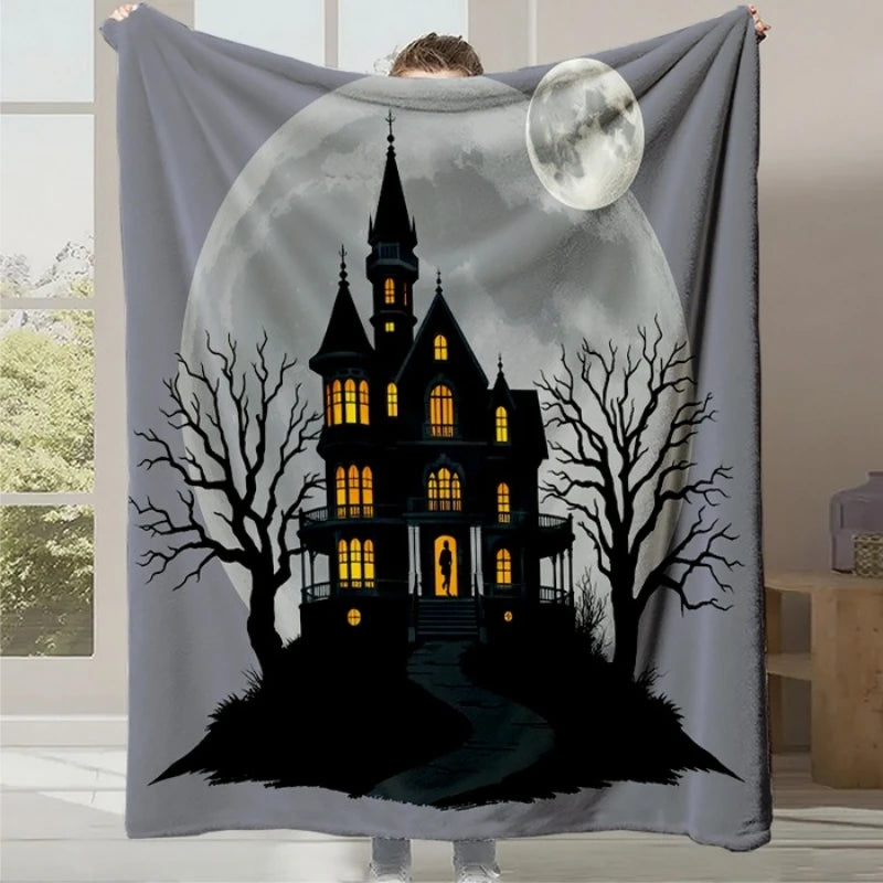 Couverture en molleton grise représentant une maison hantée mystérieuse avec des fenêtres illuminées, des arbres morts et une lune brillante dans le ciel sombre.