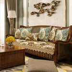 Une pièce élégante avec un canapé décoré de motifs floraux et de coussins assortis, flanqué d'une lampe de table élégante et d'un mur orné d'une décoration murale unique en son genre.