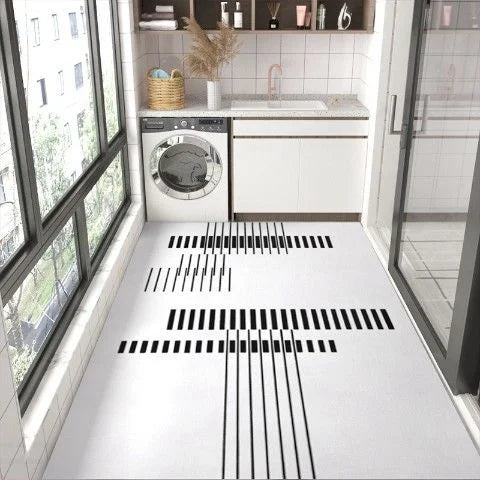 Une cuisine moderne avec une machine à laver et des éléments de décoration sur des étagères, avec un carrelage noir et blanc au sol créant un design géométrique élégant.