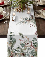 Nappe de table blanche ornée de motifs de feuillages et de baies rouges, créant une atmosphère chaleureuse et festive pour une décoration de table de Noël.