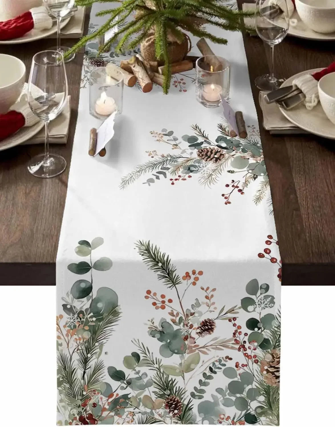 Nappe de table blanche ornée de motifs de feuillages et de baies rouges, créant une atmosphère chaleureuse et festive pour une décoration de table de Noël.