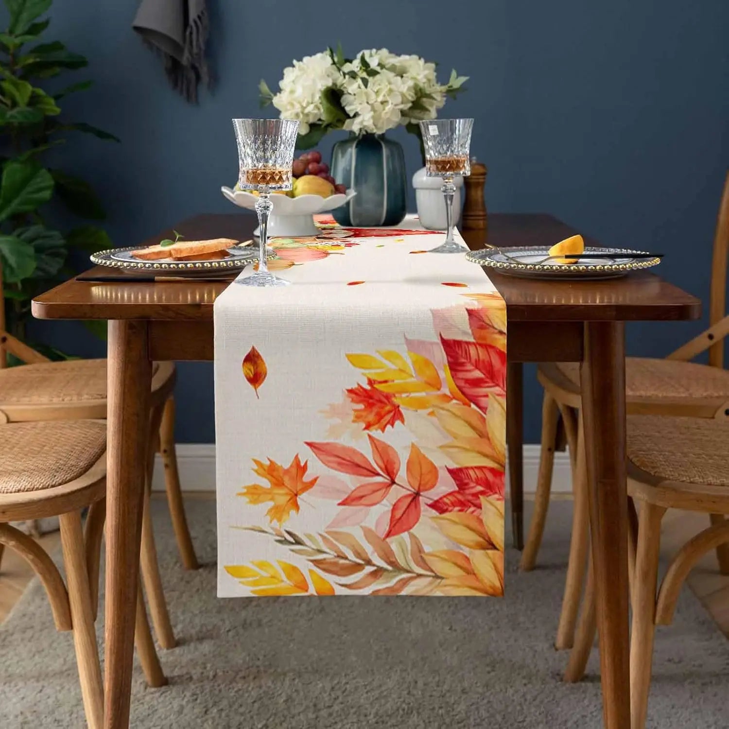 La table est élégamment dressée avec des fleurs fraîches, des verres à vin et des fruits, créant une atmosphère accueillante pour profiter d'un repas convivial.