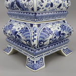 Une élégante urne en céramique bleue et blanche avec des motifs floraux et géométriques complexes.
