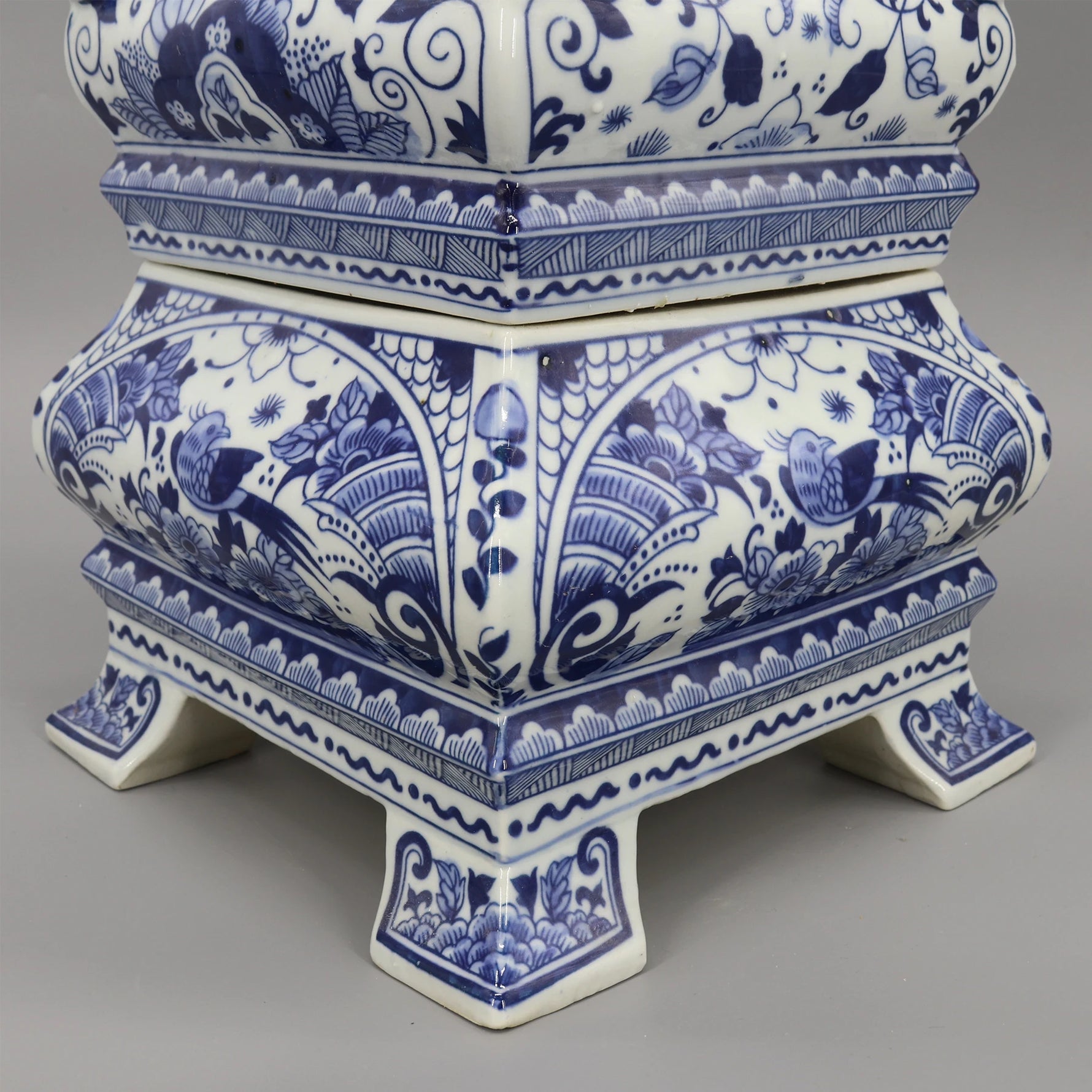 Une élégante urne en céramique bleue et blanche avec des motifs floraux et géométriques complexes.
