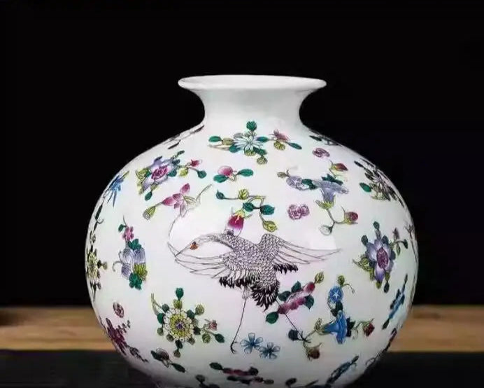 Vase en porcelaine blanc orné de motifs floraux colorés et d'un oiseau décoratif.