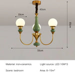 Chandelier classique vert doré globes blancs élégant chambre salon