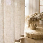 Image de rideaux élégants dans un intérieur moderne et épuré, avec une décoration naturelle comprenant un vase de fleurs séchées posé sur un tapis tressé. Idéal pour créer une ambiance chaleureuse et sereine dans votre espace de vie. Parfait pour ajouter une touche contemporaine à votre décor.