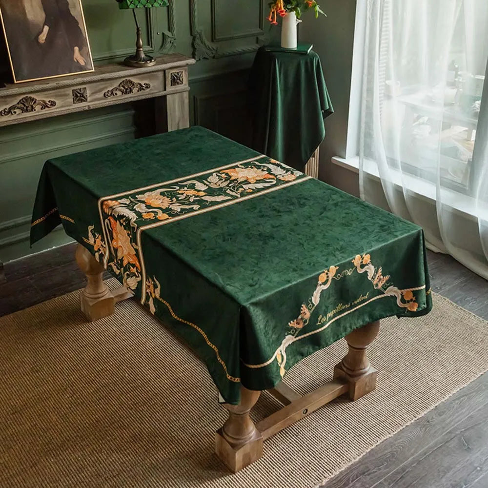 Tapis de table décoratif vert avec motif floral élégant, posé sur un meuble ancien dans un intérieur vintage.