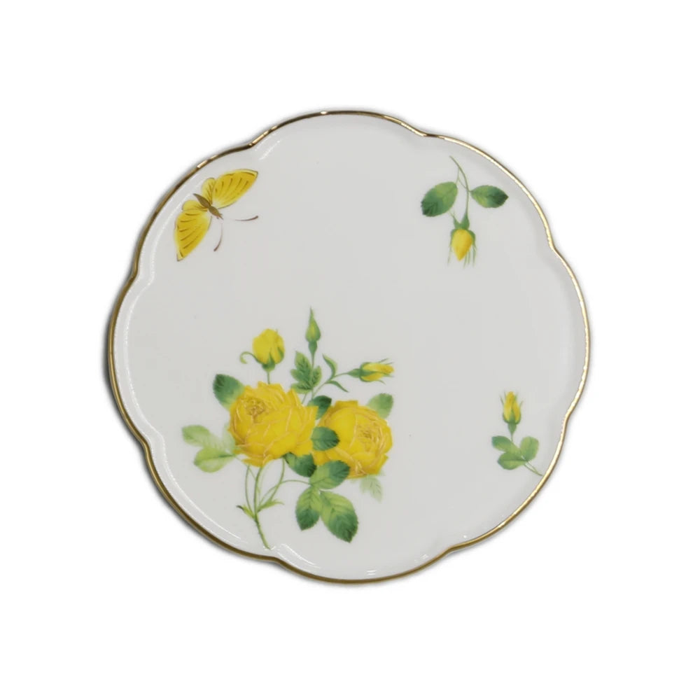 Assiette en porcelaine ornée de roses jaunes et de papillons volants, créant une scène délicate et florale.