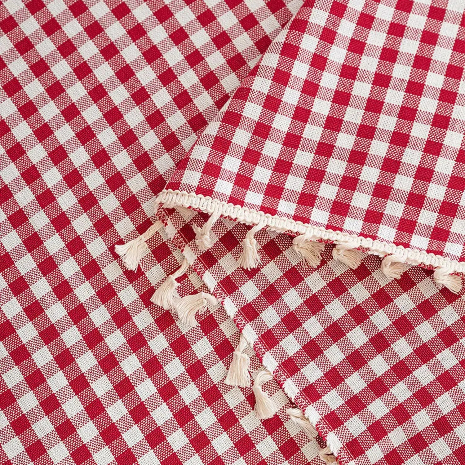 Nappe à carreaux rouges et blancs avec franges décoratives pour une table élégante et champêtre. Design classique idéal pour les repas en extérieur ou les occasions spéciales.