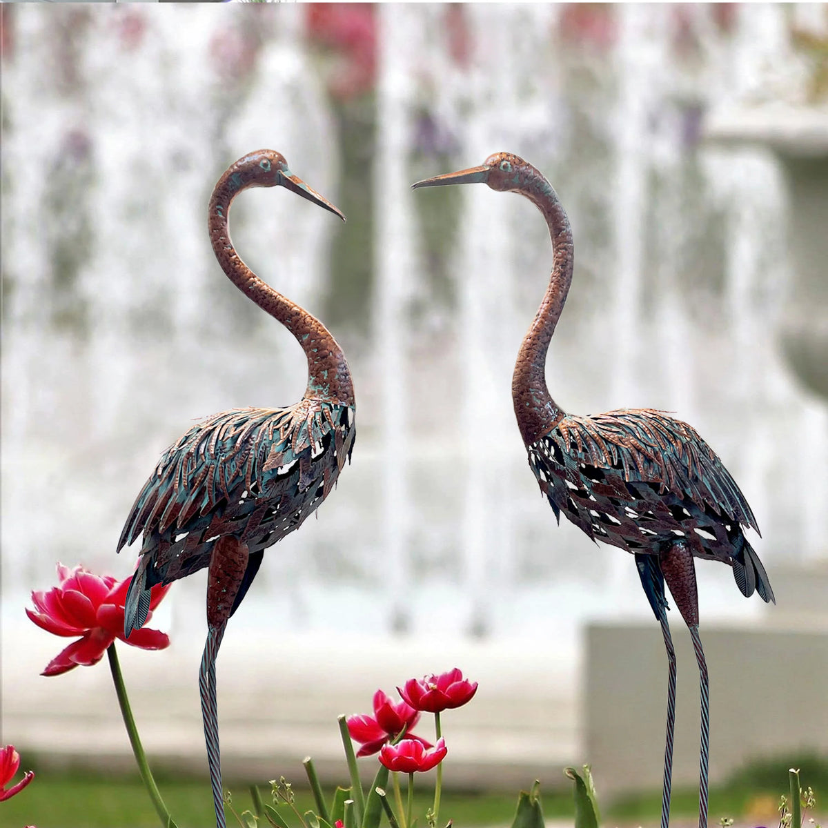statues oiseaux grue marron rouge gris vert métal patiné jardin decoratif fleurs tulipes plantes