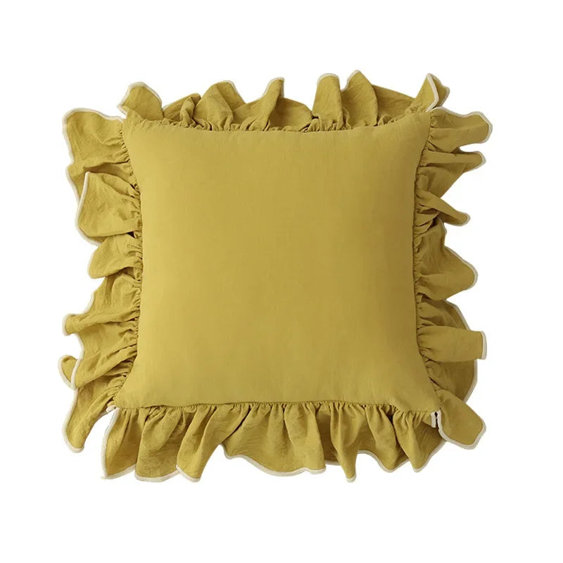 Un coussin jaune orné de volants décoratifs.