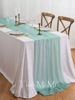 Une belle table de fête avec une nappe turquoise, des verres et de l'argenterie dorée, créant une ambiance élégante et accueillante.